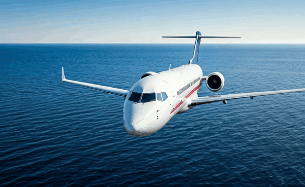 alt_text: Obrazek przedstawia lot z Polski do USA, widok przez okno na chmury i horyzont nad oceanem.