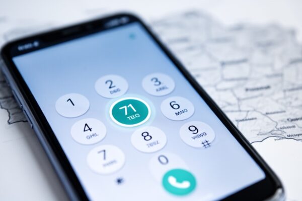 Ekran smartfona z klawiaturą telefoniczną i podświetloną cyfrą 71, w tle rozmyta mapa Polski.